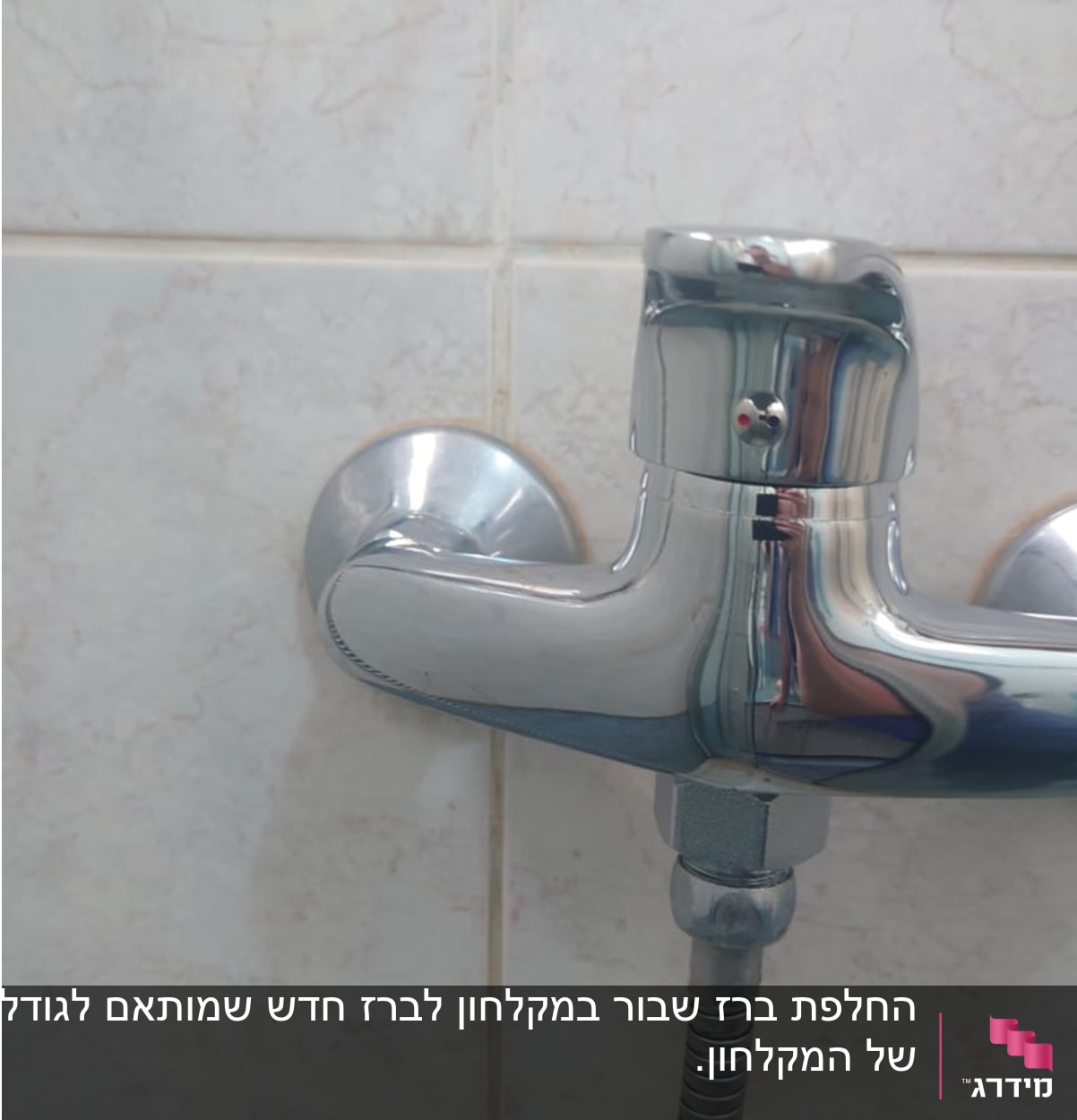 ברז כרום עם צינור מתכת על קיר אריחים